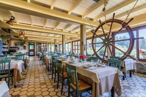 a restaurant with tables and chairs and a large wheel at Albergo Santa Barbara in Montecatini Terme +18 photos