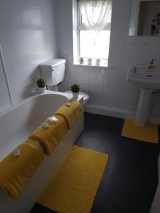 a bathroom with a bath tub with a sink and a tub at The Vale Apart Hotel in Hull