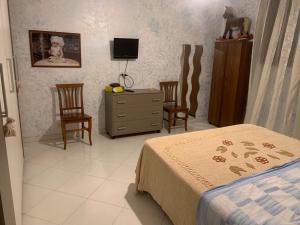 a bedroom with a bed and two chairs and a dresser at B&B arpaia in Arpaia