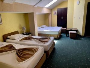 a hotel room with three beds in a room at Hotel Ilinden in Strumica