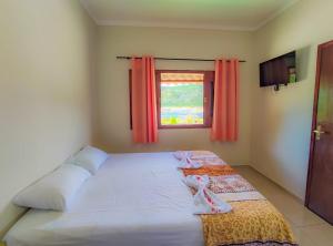 a bedroom with a bed with two pairs of shoes on it at Pousada Canoa de Tolda II in Piranhas