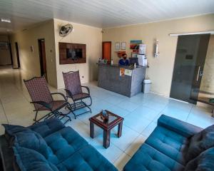 a living room with a blue couch and a table at Pousada Canoa de Tolda in Piranhas