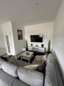 ein Wohnzimmer mit einem Sofa und einem TV in der Unterkunft Sweet Home am Arendsee in Arendsee