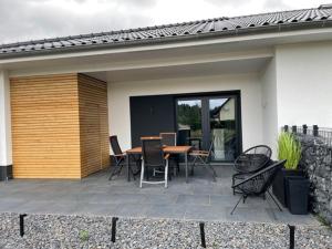 eine Terrasse mit einem Tisch und Stühlen neben einem Haus in der Unterkunft Sweet Home am Arendsee in Arendsee