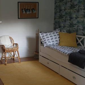 a bedroom with a bed and a chair in it at Sydåbacka Guest House, a Room with a Sauna in Kirkkonummi