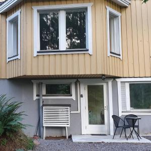 una casa con dos sillas y una mesa frente a ella en Sydåbacka Guest House, a Room with a Sauna, en Kirkkonummi