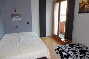 a bedroom with a white bed and a window at Les Clarines in Passy