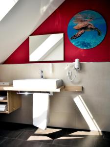 łazienka z umywalką i czerwoną ścianą w obiekcie R & J Hotel w mieście Rust