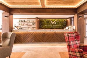 ARIETES MARMONT Resort في تاترانسكا ستربا: بار في مطعم يحتوي على كرسيين