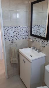 ein Badezimmer mit einem weißen Waschbecken und einem Spiegel in der Unterkunft Bella Vista in Cipolletti