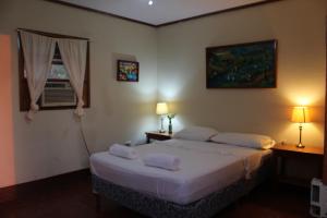 a bedroom with a bed and two lamps and a window at Hotel La Omaja in Mérida