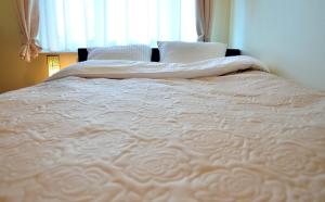 - un grand lit blanc dans une chambre avec fenêtre dans l'établissement Willa Horyzont, à Hel