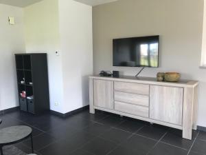 a living room with a flat screen tv on a wall at Huis Marlin in De Haan