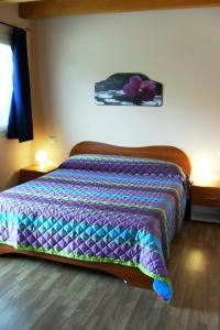 una camera da letto con un letto con un piumone colorato di Alle Vallesse ad Altavilla Vicentina