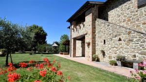 un edificio de piedra con flores delante en Le Terre Di Giano, en Paciano