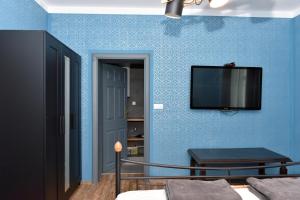 a room with a tv on a blue wall at Vacation house Stala la la in Požega