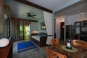 a living room with a bed and a dining table at Casa Frangipani in Montezuma