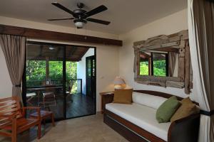 a living room with a couch and a ceiling fan at Casa Frangipani in Montezuma
