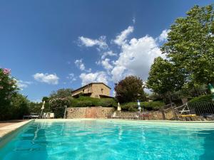 a swimming pool with a building in the background at Le Terre Di Giano in Paciano