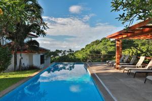 蒙特苏马素馨别墅的房子旁边有带躺椅的游泳池