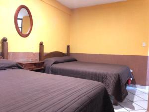 a bedroom with two beds and a mirror on the wall at San Pablo in Pátzcuaro