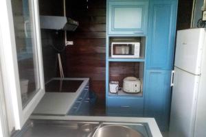 a small kitchen with a sink and a microwave at Lodgentomo in Matoury