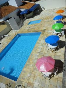 una vista sul tetto di una piscina con ombrelloni e sedie di Pousada Casablanca Águas de São Pedro ad Águas de São Pedro
