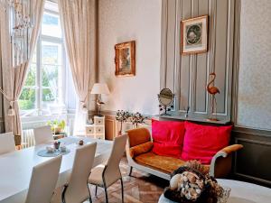 sala de estar con mesa y almohadas rojas en Les chambres d'hôtes du Manoir de Roz-Maria en Quintin