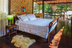 um quarto com uma cama e uma parede de tijolos em Sitio na Serra dos Orgaos com rio de aguas cristalinas em Guapimirim