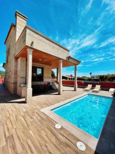 a house with a swimming pool and a patio at CHALET A LANZADA in Sanxenxo