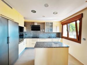 a kitchen with white cabinets and a counter top at CHALET A LANZADA in Sanxenxo
