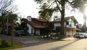 a house with cars parked in front of it at Hospedagem Vida e Natureza in Gramado