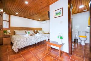 a bedroom with a bed and a toilet at Villa Dos Cedros in Pereira