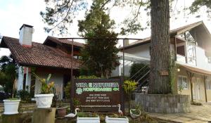 a house with a sign in front of it at Hospedagem Vida e Natureza in Gramado