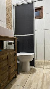 プライア・グランデにあるCabana Refúgio canyon Malacaraのトイレとガラスのシャワー付きのバスルーム