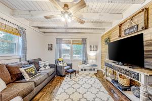 a living room with a couch and a flat screen tv at Honey Bear Hideaway in Helen