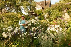 a woman standing in a garden filled with flowers at All Seasons Bed & Breakfast in Kerpen