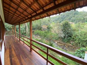 a balcony with a view of a forest at Espaço Beira Rio in Nova Friburgo