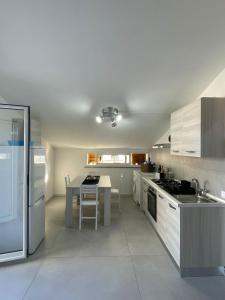 une cuisine blanche avec une table et une cuisinière four supérieur dans l'établissement BeDa House, à Giardini Naxos