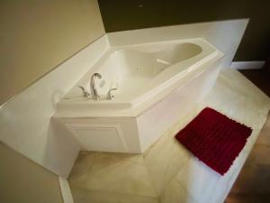 baño con lavabo blanco y alfombra roja en Rodeway Inn en Swansea