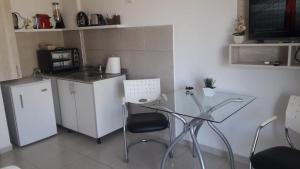 a kitchen with a table and chairs and a microwave at Plaza 376 in Chivilcoy