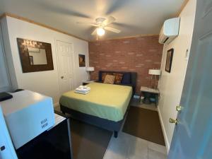 a small room with a bed and a ceiling fan at Studio Apartment Antonine in New Orleans