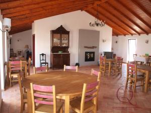 a dining room with a wooden table and chairs at Quinta de São Gabriel in Castro Marim