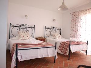 a bedroom with two beds and a window at Quinta de São Gabriel in Castro Marim