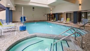 a large swimming pool with chairs and tables at Best Western Plus InnTowner Madison in Madison