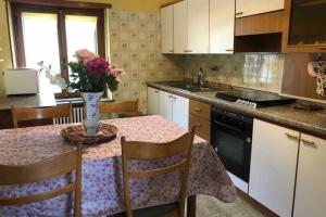 a kitchen with a table with a vase of flowers on it at La Maison des Hirondelles Alloggio ad uso turistico - VDA SAINT-PIERRE 0035 in Saint-Pierre