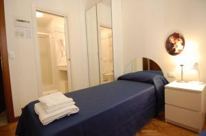 1 dormitorio con 1 cama con sábanas azules y espejo en Santa Margherita Guest House, en Venecia