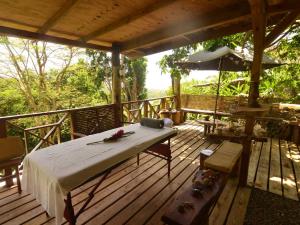 une terrasse en bois avec un lit et un parasol dans l'établissement The Fan Villa, à Port Antonio
