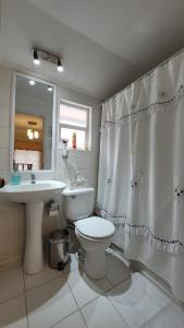 a bathroom with a toilet and a sink at Prairie's House in Temuco