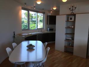 a dining room with a table and chairs and a kitchen at The Silos Apartments in Raglan